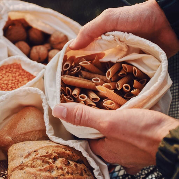 Nachhaltige Unverpackt Beutel von samebutgreen, gefüllt mit Brot, Nudeln, Linsen und Nüssen.