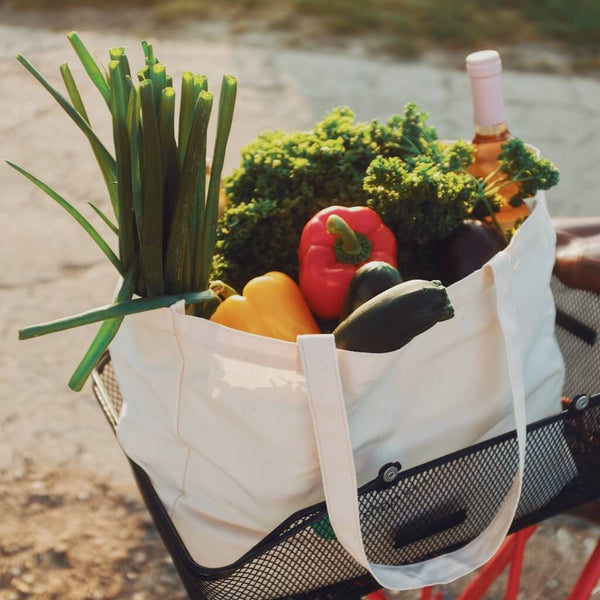 Nachhaltige samebutgreen Einkaufstasche aus Bio Baumwolle, gefüllt mit Obst und Gemüse.