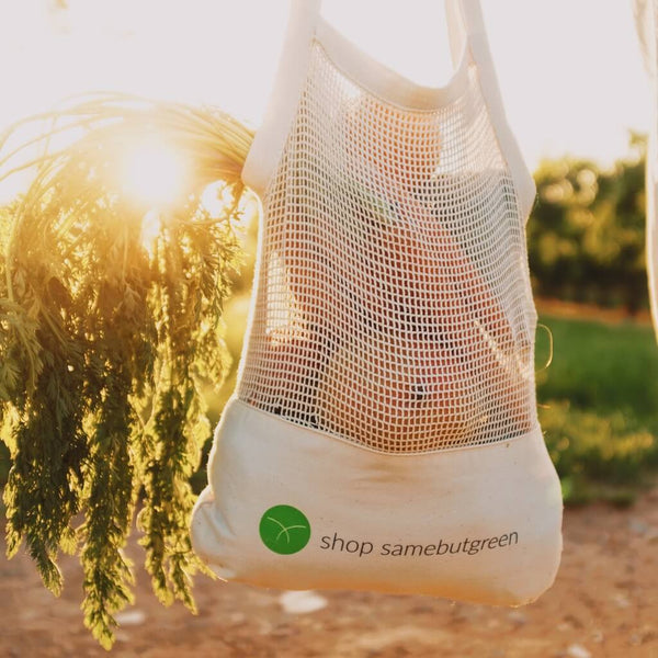 Plastikfreie Netztasche für Einkäufe, gefüllt mit Gemüse und mit shop samebutgreen Aufdruck.